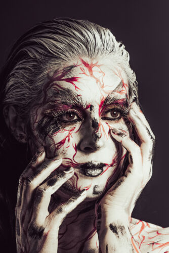 Portrait body painting, couleur blanc et rouge, un travail artistique avec Margaux qui pose les mains sur le visage.