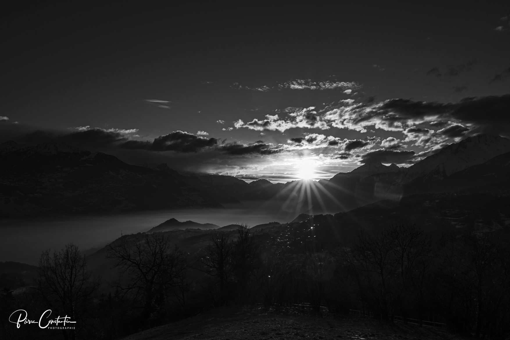 Coucher de soleil dans la plaine du Rhône en Valais. Les montagnes et les nuages forment un beau tableau